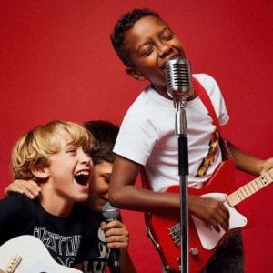 three children singing and playing Loog guitar